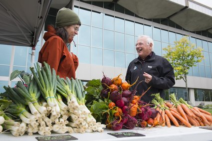 Une femme et un homme âgé à un kiosque de fruits et légumes