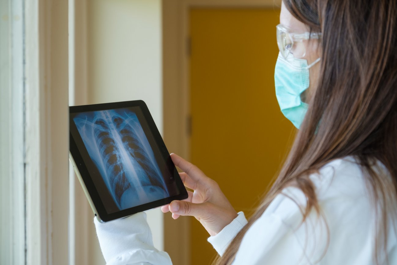 Femme médecin analysant une radiographie sur une tablette électronique