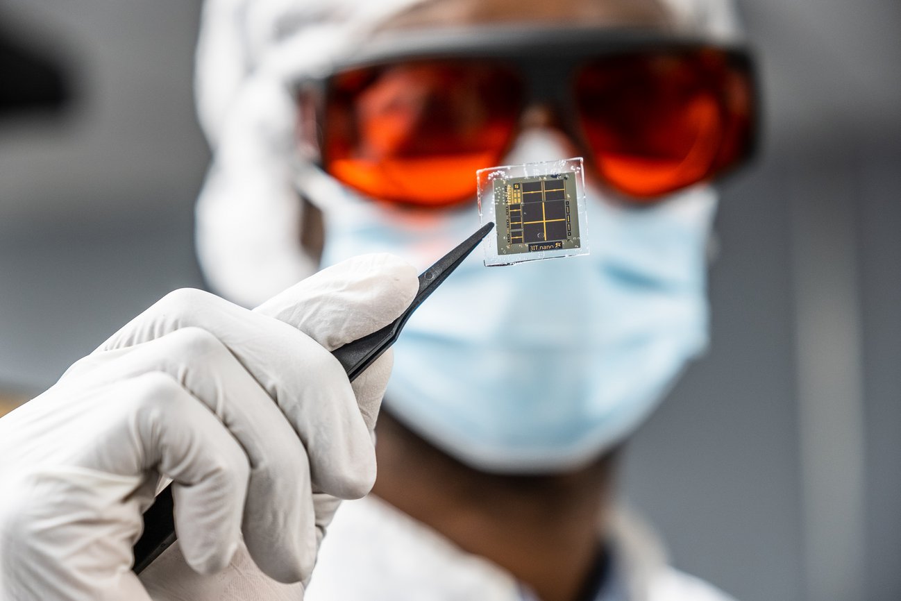 Chercheur tenant une petite cellule solaire avec une paire de pinces