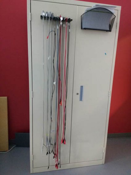 Des fils d'interconnexion pour tests accrochés sur une armoire beige