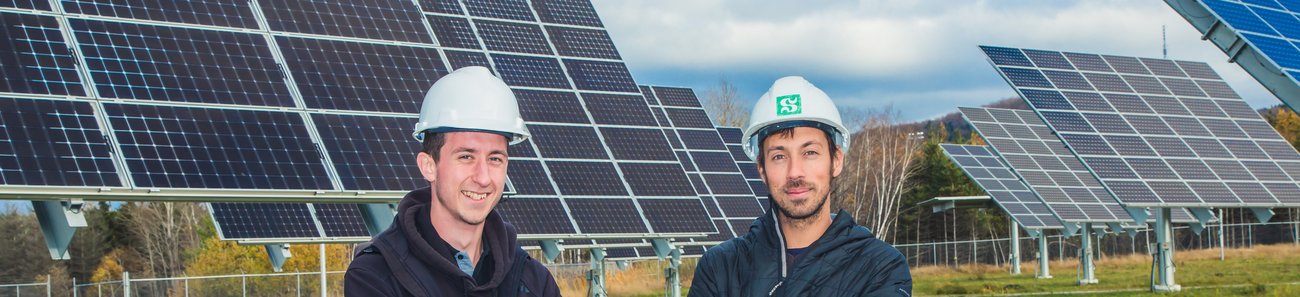 Photo de deux étudiants du 3IT devant le parc solaire