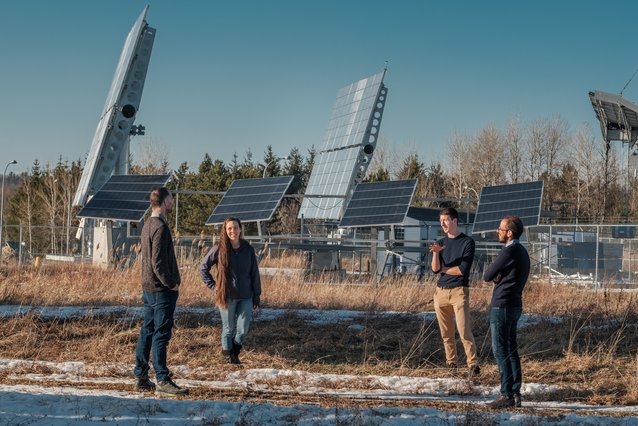 Les 4 collaborateur et colloboratrice devant le parc solaire du 3IT