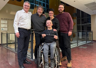 Photo de groupe montrant 5 personnes, dont une en fauteuil roulant