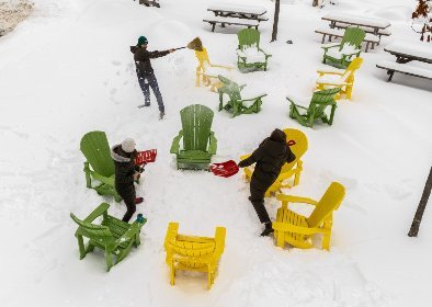 Étudiants, vus de haut, se lançant de la neige avec des pelles, dans un décor chaleureux sur le Campus de l'Université de Sherbrooke