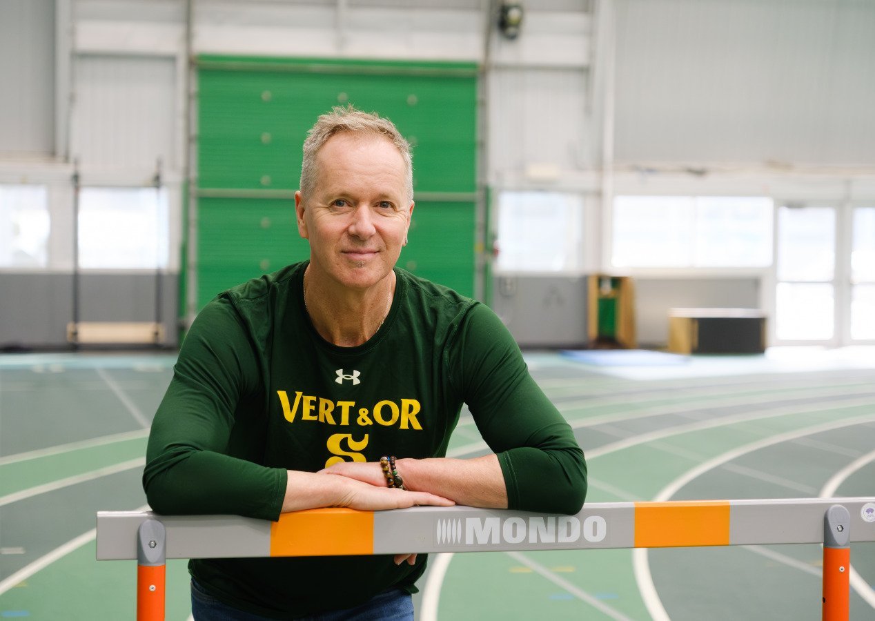 Marc Samsom, ancien athlète de l'UdeS, posant dans le stade intérieur, sur la piste d'athlétisme