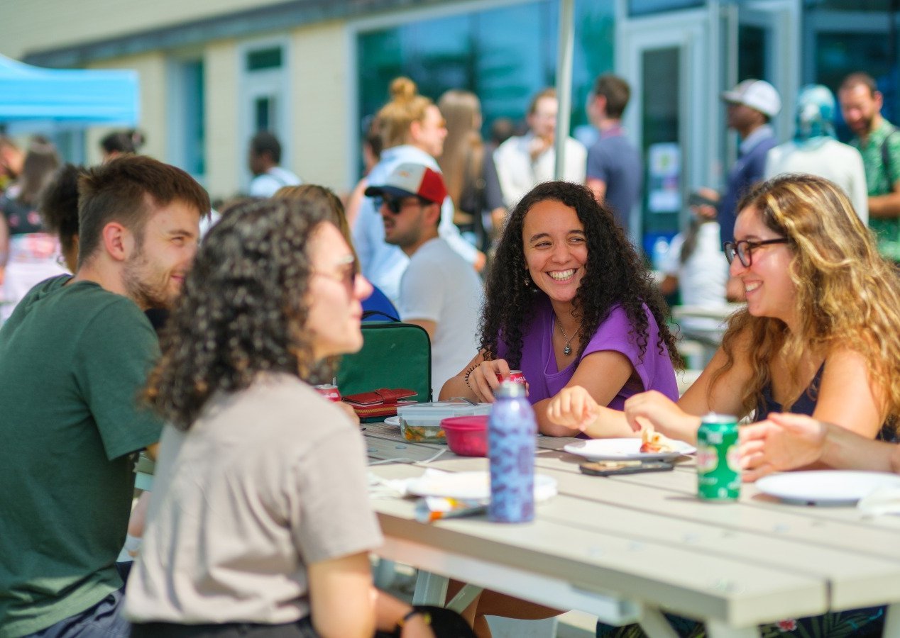 Des étudiantes et étudiants discutent autour d'une table à pique-nique