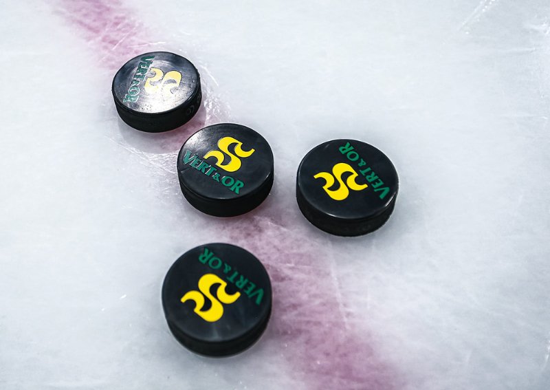 Quatre rondelles de hockey sur la glace, portant le logo de l'université de Sherbrooke#