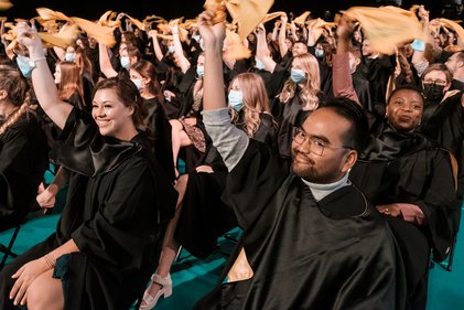Les diplômées et diplômés agitent leur drapeau