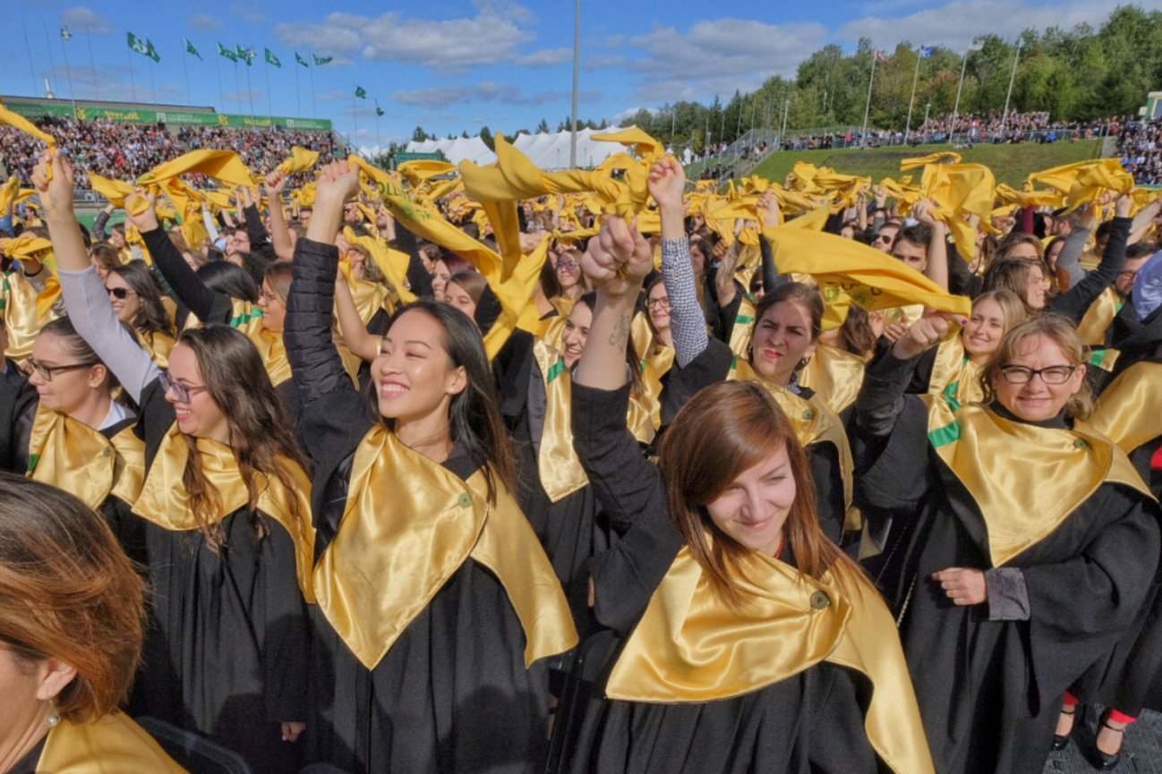 Diplômés agitant un petit foulard jaune dans les airs