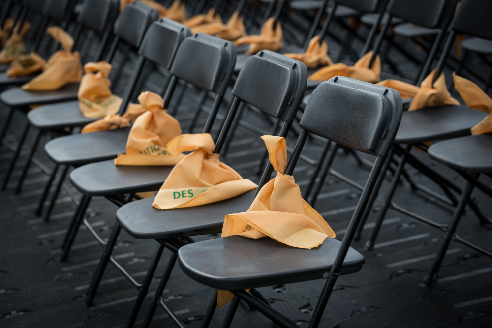 Une rangée de chaises vides sur lesquelles sont déposées des foulards jaunes