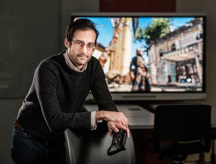 Étudiant doctorant devant un jeu vidéo