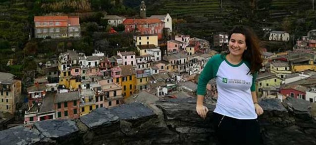 Une étudiante devant un village de montagne à l'étranger