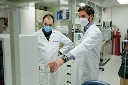 Deux chercheurs analysent des données scientifiques devant un ordinateur