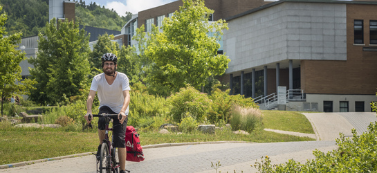 Un étudiant à vélo au campus principal