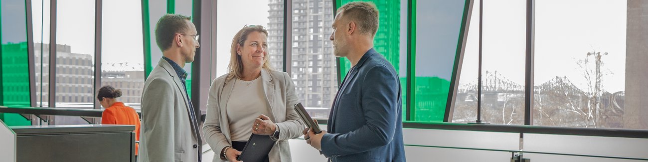 Trois personnes debout discutent