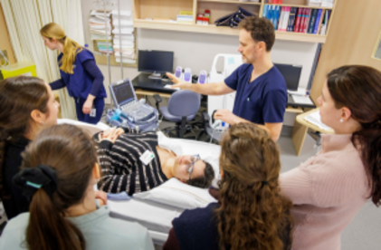 Instructeur avec des participants et une patiente sur une civière avec de l'équipement médical