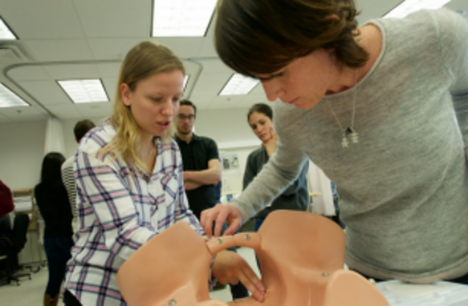 Mannequin d'une femme qui accouche avec une instructrice et une participante