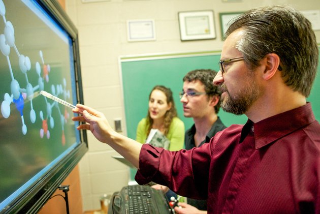 Un professeur apportant des explications à l'aide des outils technologiques du département de Chimie
