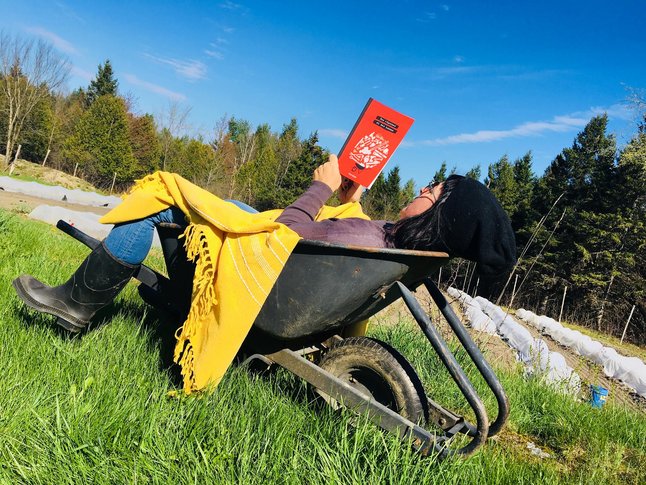 Julie qui lie son roman dehors.