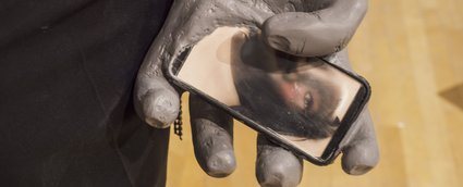La main d'une statue tient un téléphone cellulaire