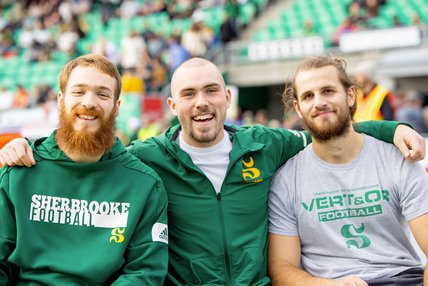 Trois fiers membres du Vert & or Football sourient à la caméra