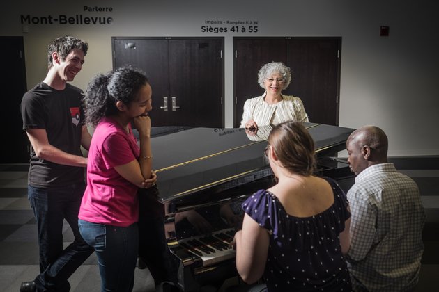 Professeure Jocelyne Faucher avec des étudiants autour d'un piano au Centre culturel de l'Université de Sherbrooke.