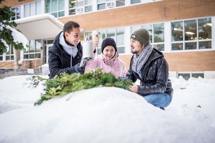 Deux étudiants et une étudiante font une expérience dans la neige