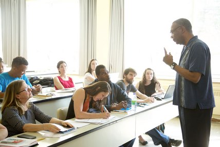 Un professeur parle à ses étudiants assis en classe dans une atmosphère conviviale