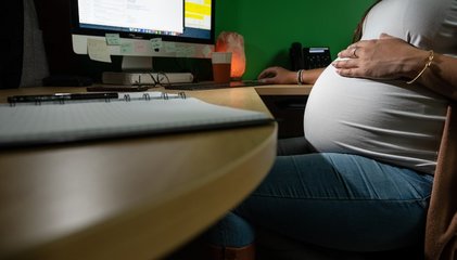 Femme enceinte assise à son bureau