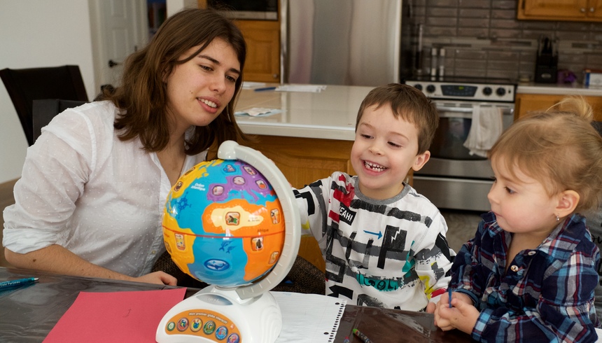 Étudiante et deux enfants regardant un globe terrestre