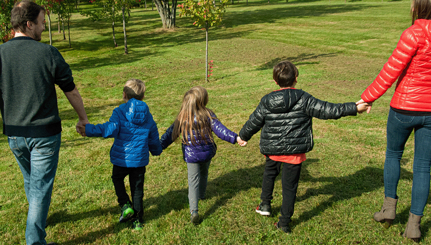 Famille se tenant par la main dans un parc