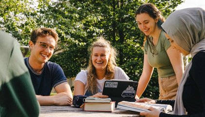 Personnes étudiantes assisent à une table de pique nique