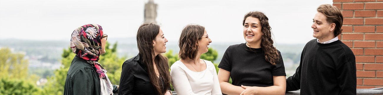 Un groupe d'étudiants discute sur la terasse de l'École de gestion
