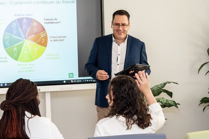 Une personne enseignante est devant une classe