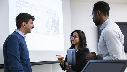 Professeur Martino Pelli et deux doctorants discutent