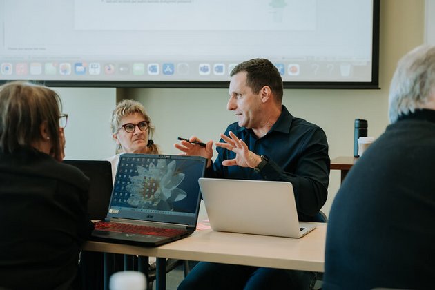 Personne qui donne des explications devant un ordinateur portable