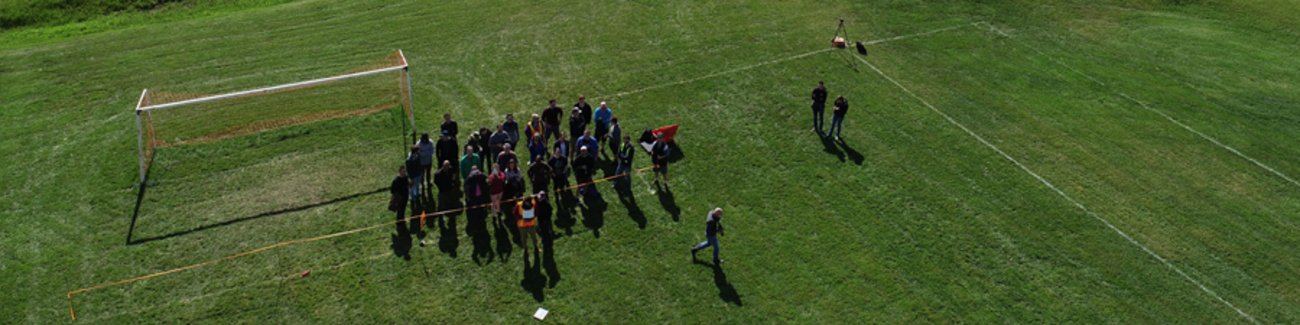 Une équipe de recherche sur un terrain de football, vue de haut, par un drone