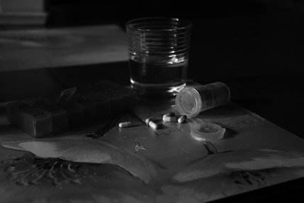Des pilules sont posées à côté d'un verre d'eau