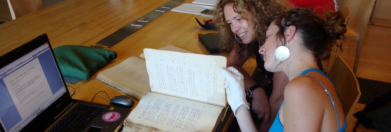 Une étudiante et une professeure examinent le filigrane dans un registre de compoix