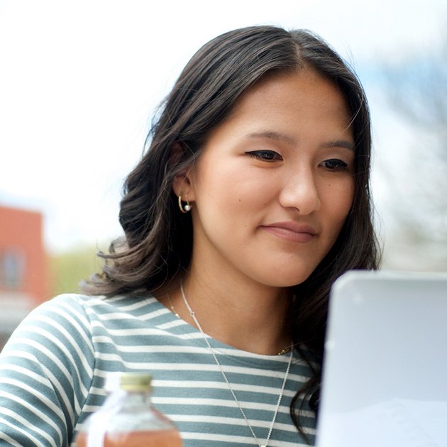 Étudiante d'origine asiatique devant son ordinateur portable