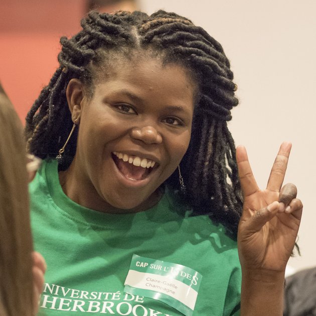 Jeune étudiante noire qui sourit et fait le signe «Victoire» avec ses doigts.»