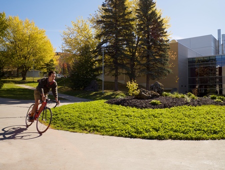 Un étudiant roule en vélo sur le campus