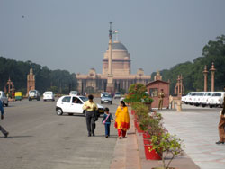 Une jeune famille indienne se promne sur la voie royale  Delhi. En arrire-plan, le Palais prsidentiel ou Rashtrapati Bhawan.