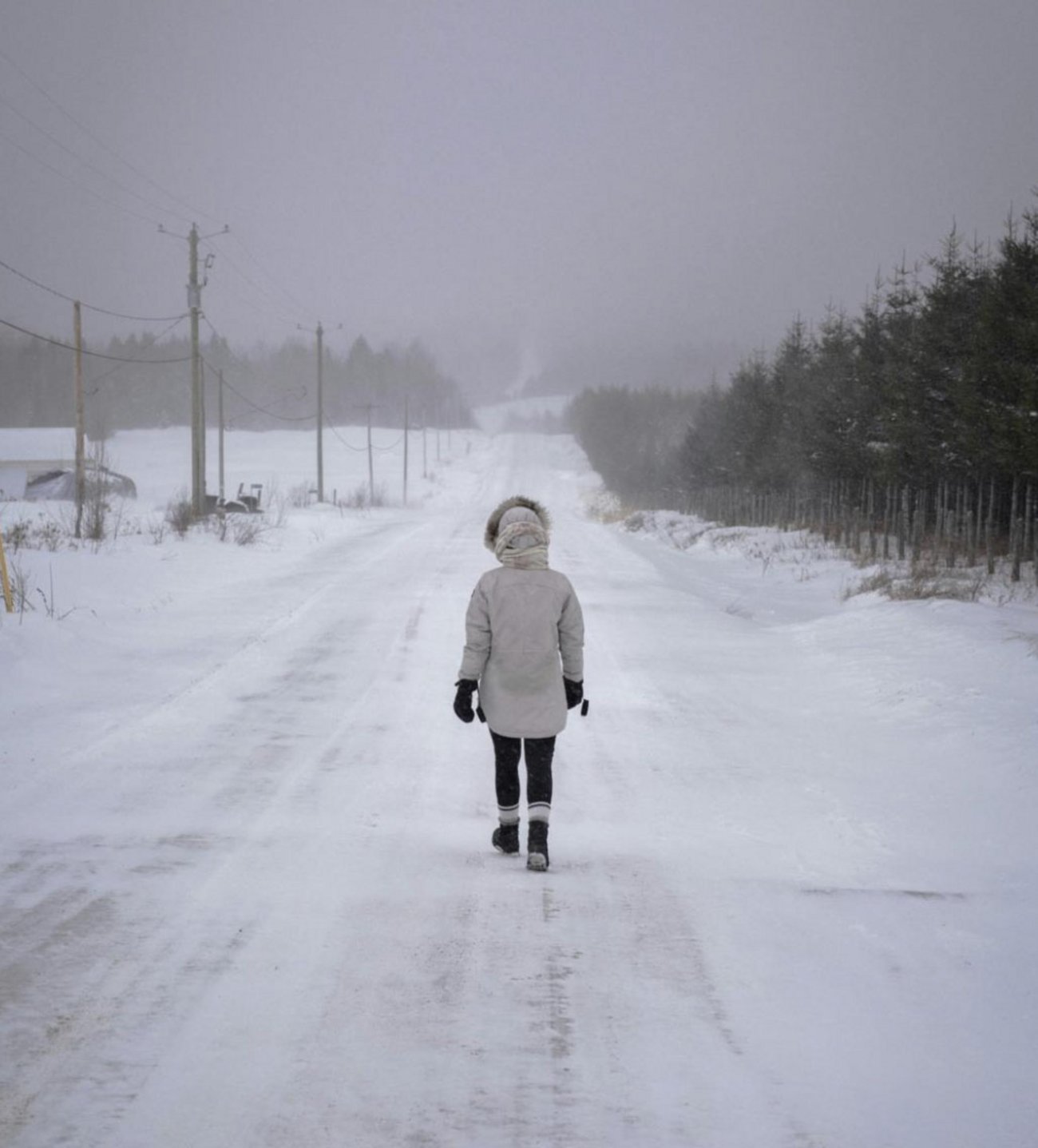 Photo représentant une femme marchant seule sur une route enneigée