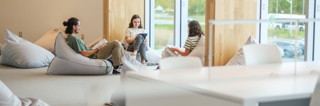 Étudiantes et étudiant assis à la bibliothèque du Campus de la santé