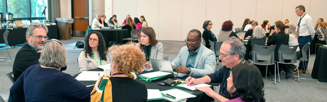 Membres du personnel, incluant le recteur, réunis autour de tables de travail