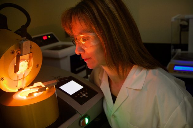 Photo of a woman looking at a machine in a laboratory