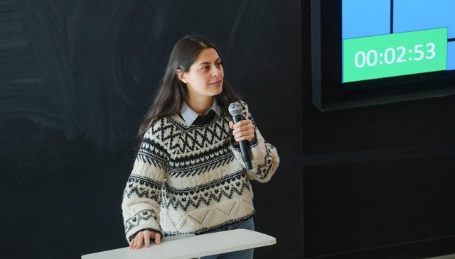 Photo de Maryam Afkari présentant son projet de thèse de doctorat.