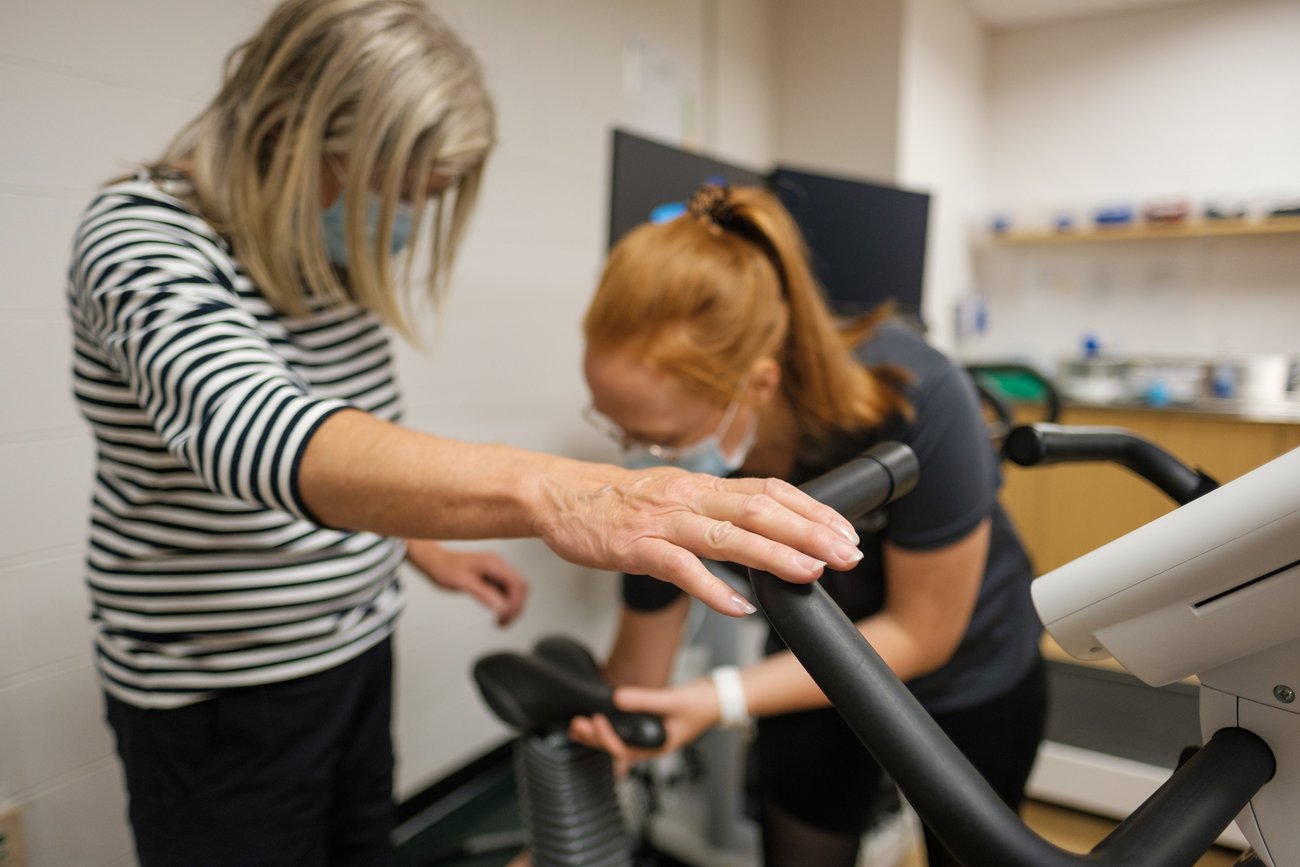 [Translate to English:] Kinesiologist who supervises the installation of a person on a treadmill at the UdeS Kinesiology Clinic.