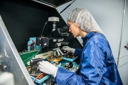 Photo of someone looking into a microscope in a laboratory